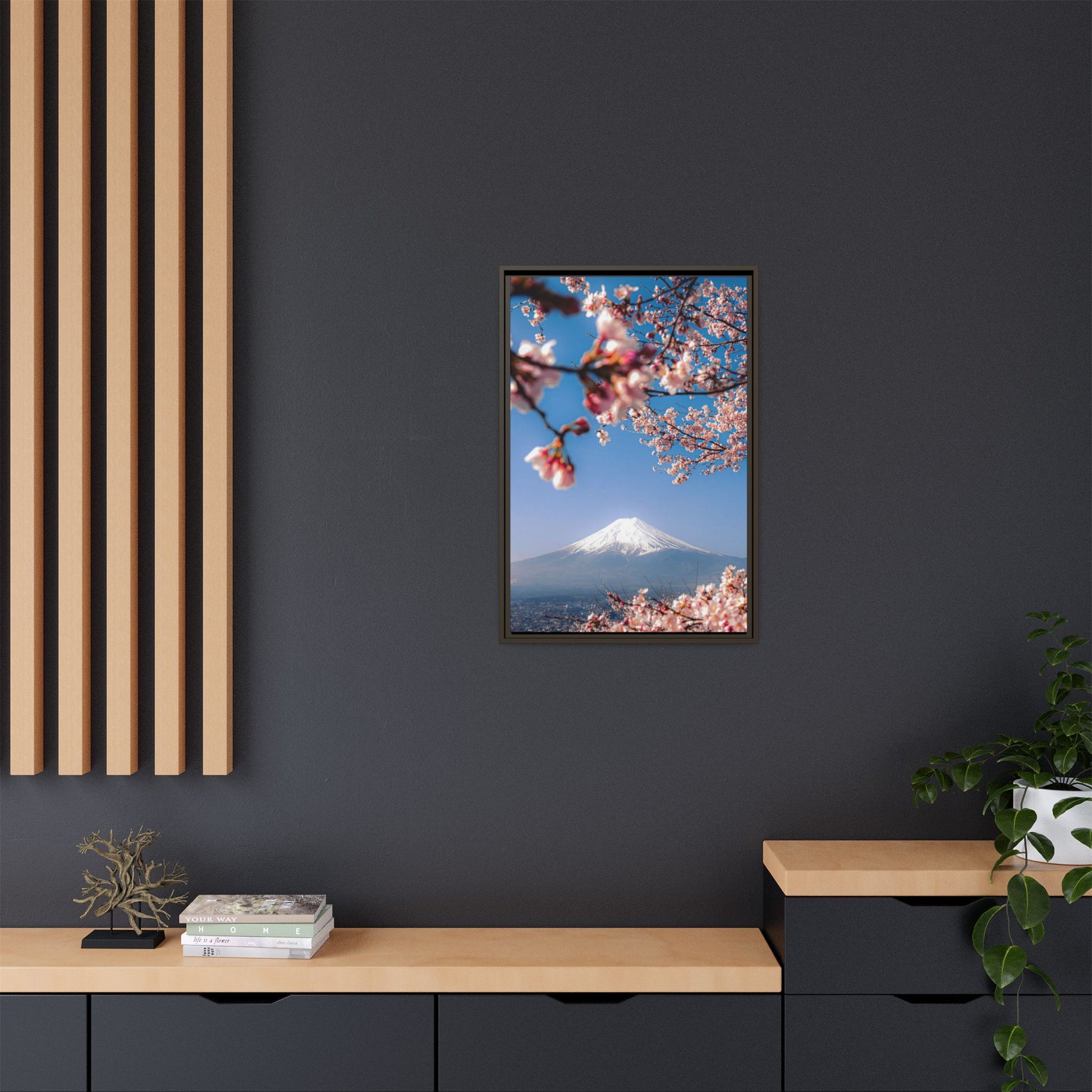Framed artwork of cherry blossoms and Mount Fuji on a dark wall with wooden shelves.